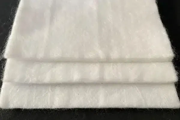 Several layers of pale nonwoven geotextile fabric shown together.